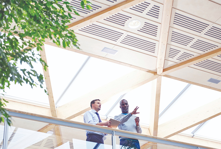Two professionals standing and talking in a modern office setting